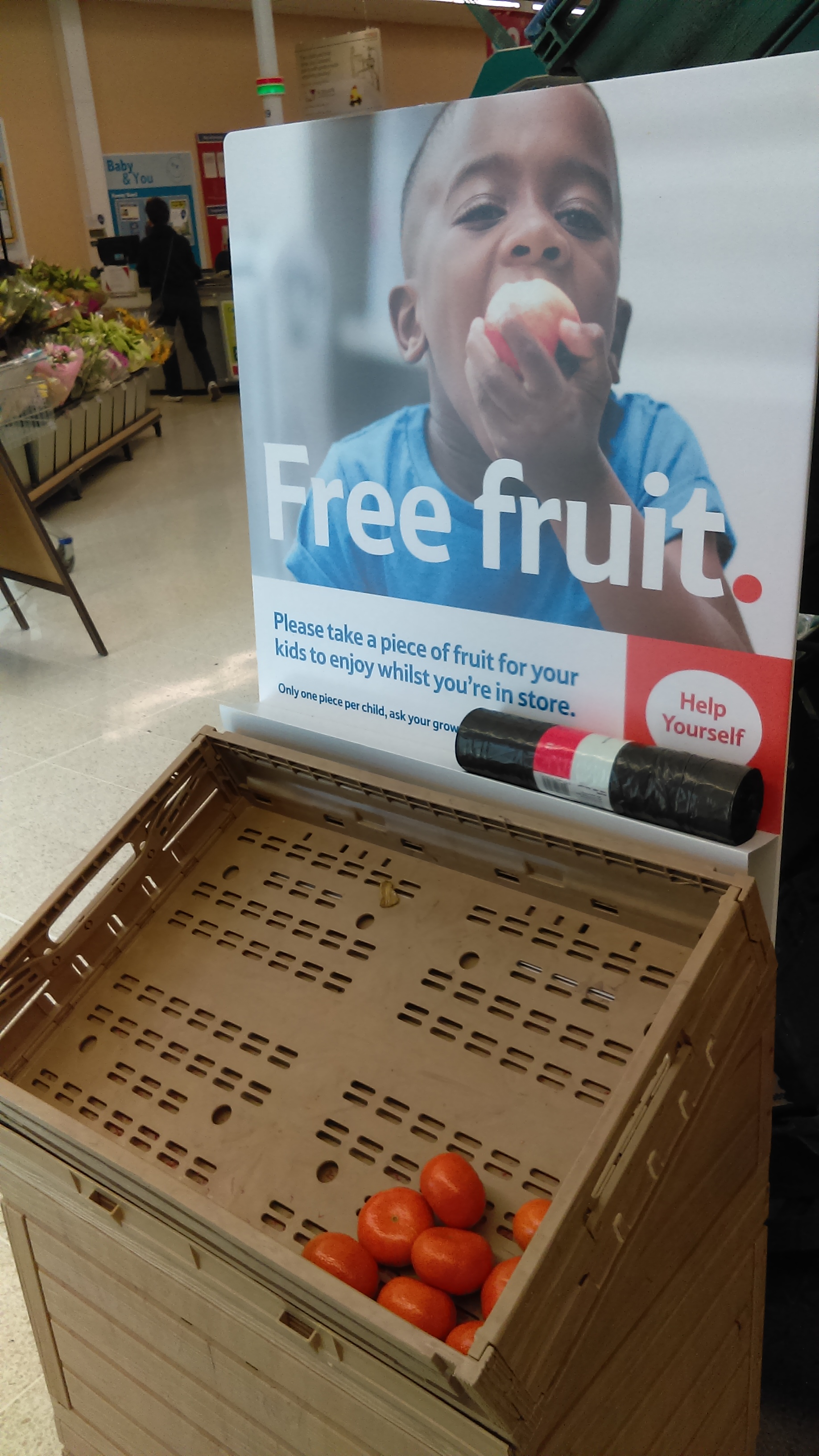 Cartell de fruita gratuïta per a nens en un supermercat TESCO